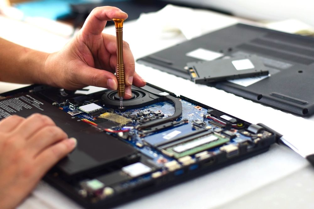 Technician,computer,technician,laptop,motherboard,repairman,using,screwdriver,to,remove